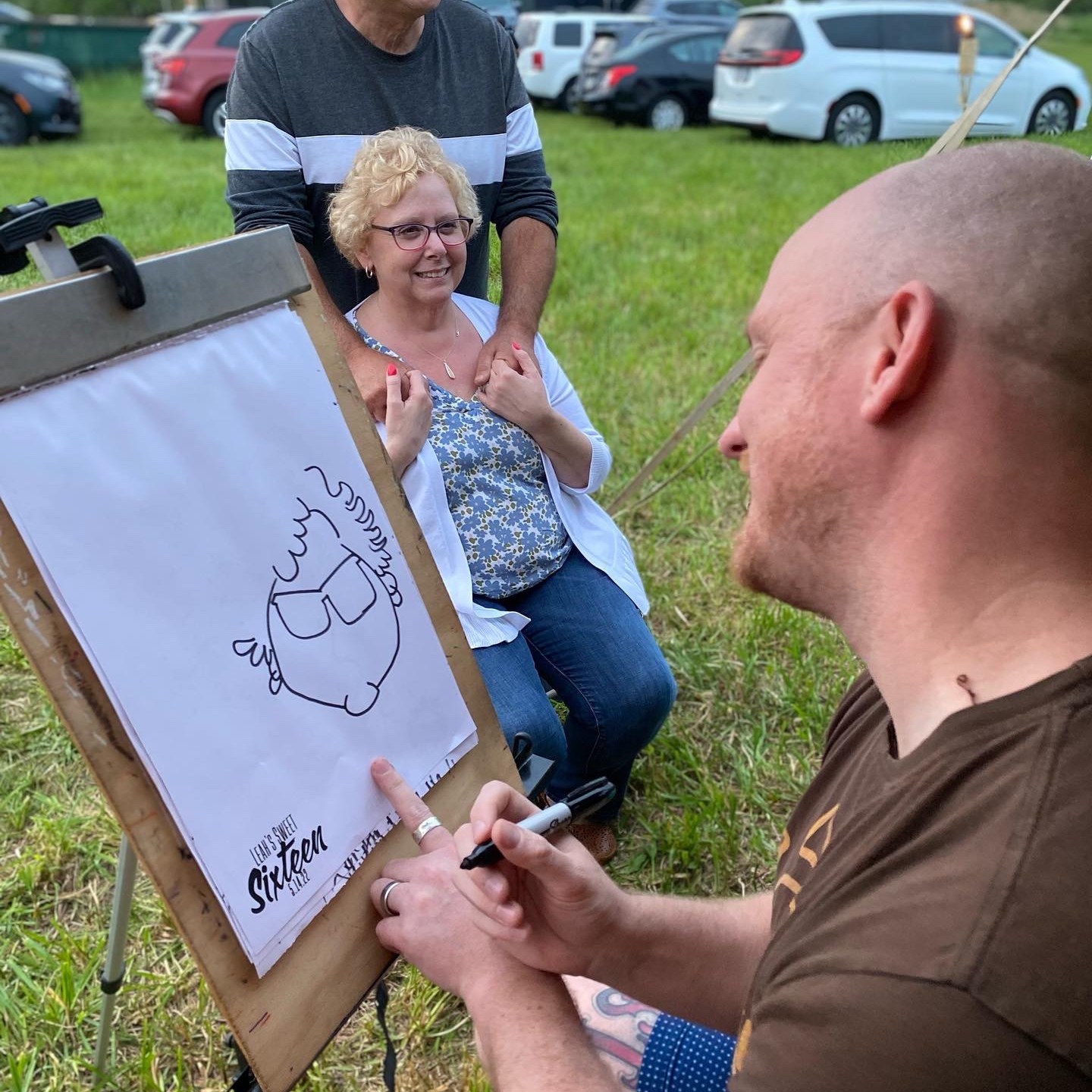 A couple sitting for a caricature at a Sweet Sixteen party