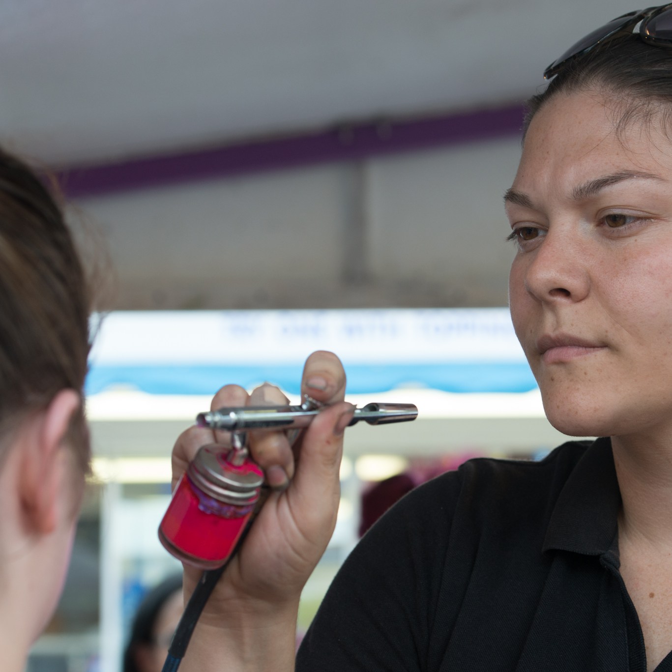 An artist airbrush face painting someone's face
