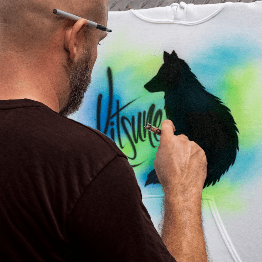 An artist airbrushing an anime themed t-shirt