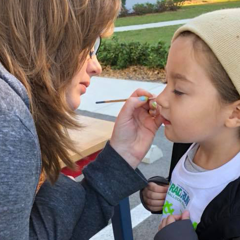 A face painter painting a little kids face