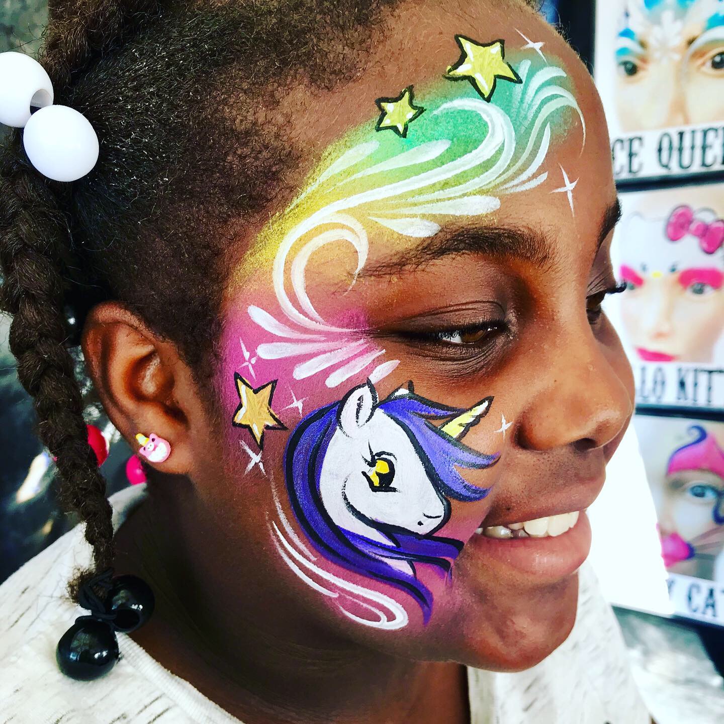 A starry rainbow unicorn cheek face paint design