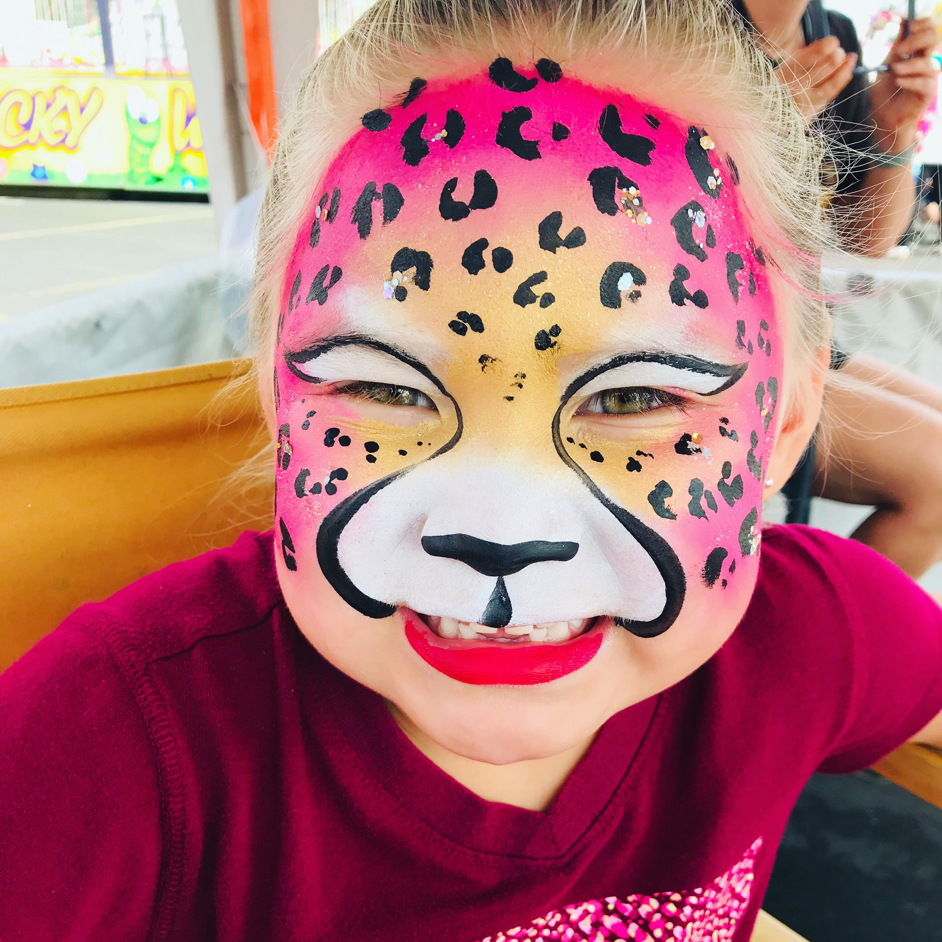 A pink and gold leopard print face paint