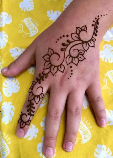 A henna tattoo on the hand with leaves and vines
