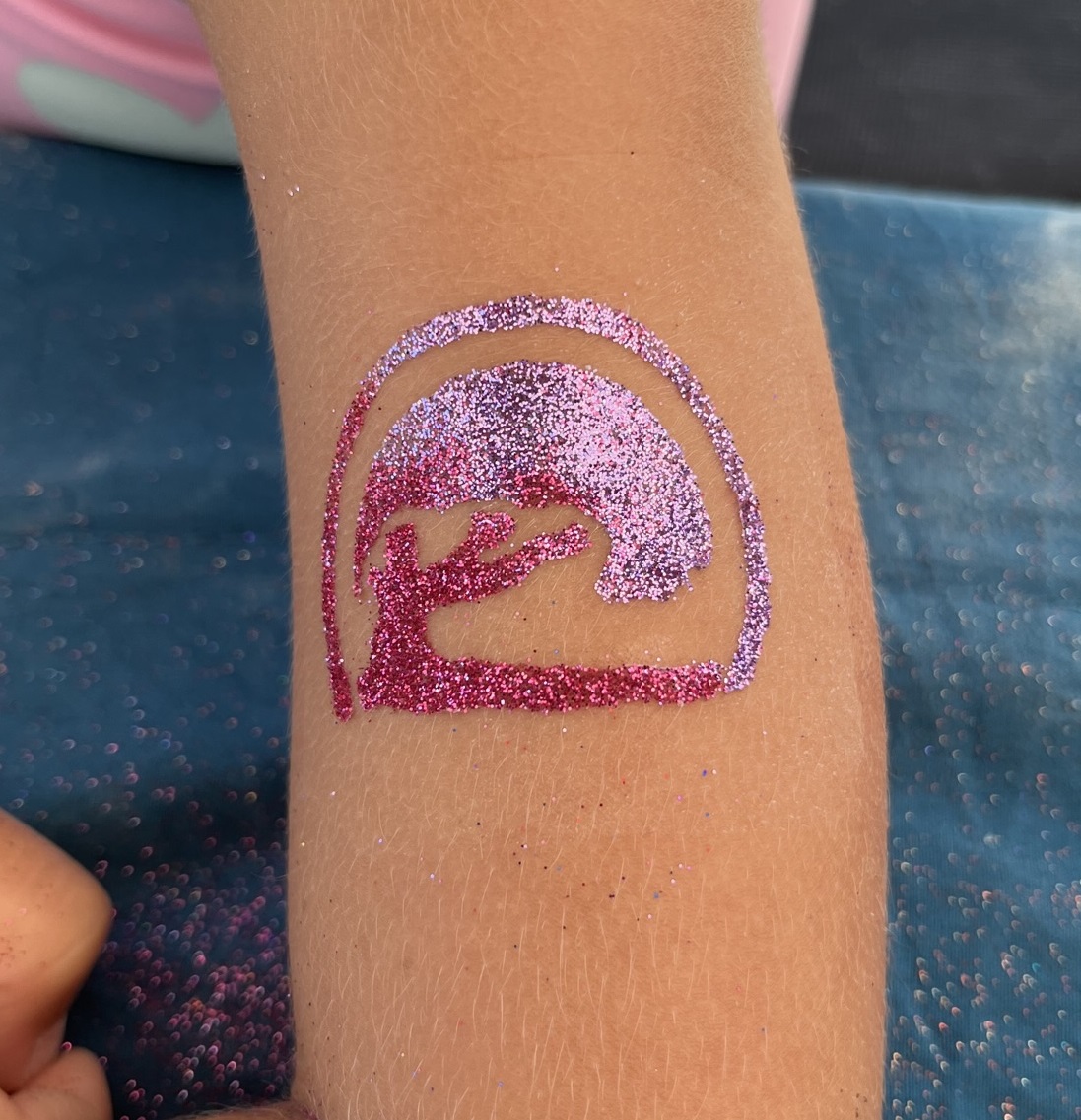 A custom pink sparkly Schell Brothers logo glitter tattoo