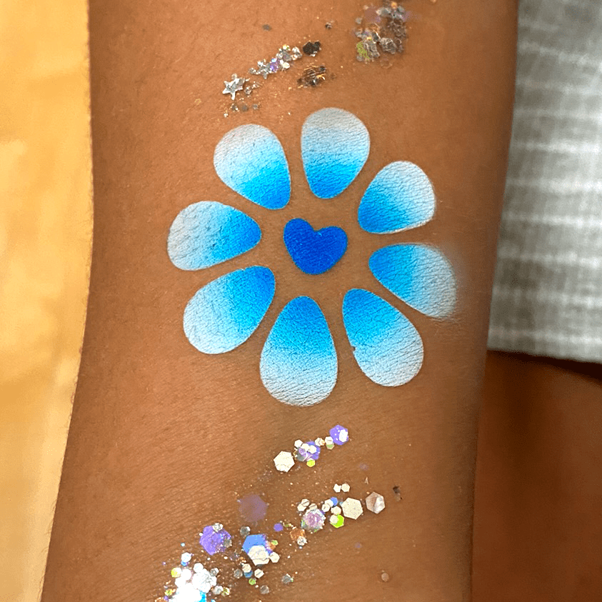 A blue and white flower airbrush tattoo on the arm at a school event