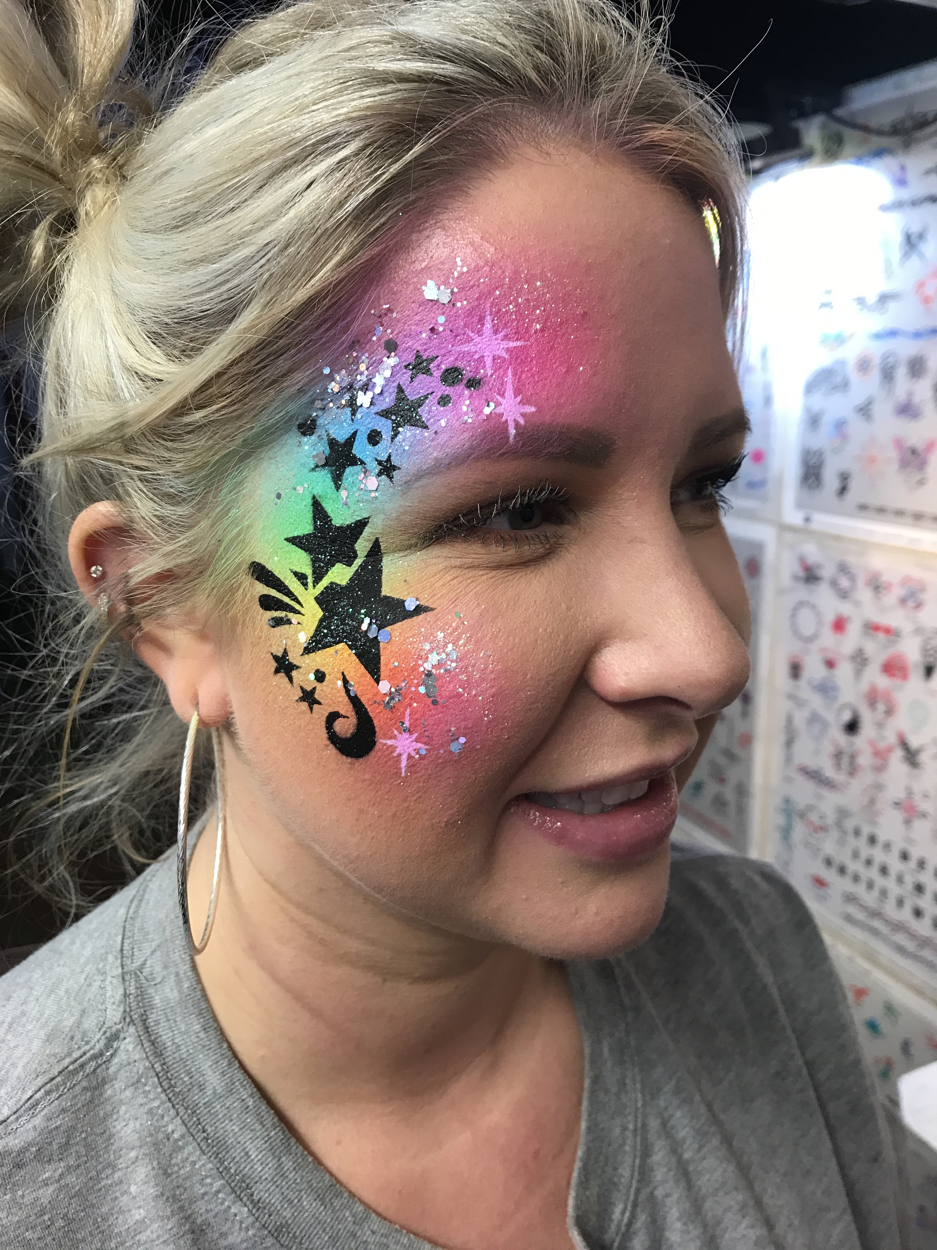 A rainbow star themed airbrush face paint