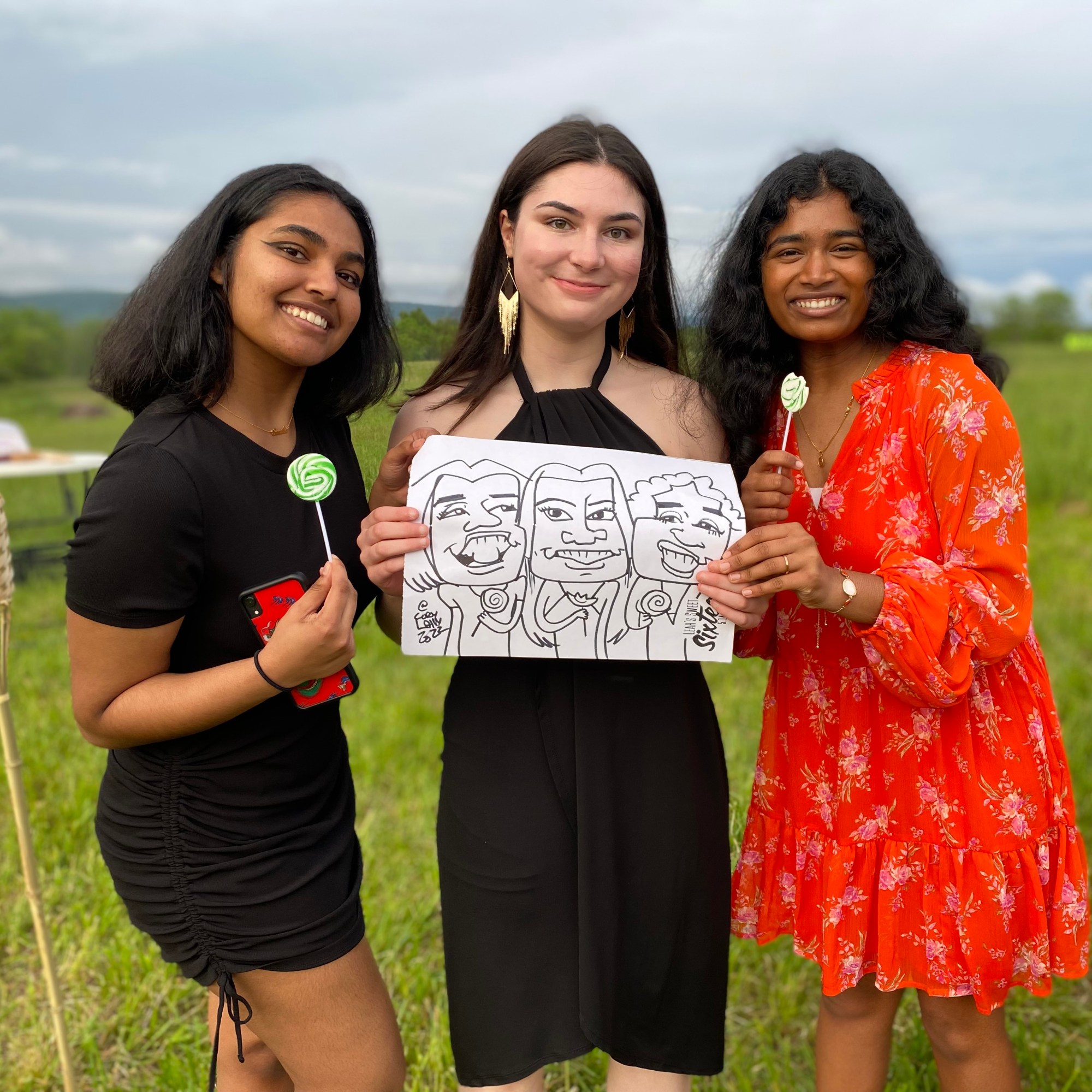 Three girls standing in a field modeling their black and white group caricature