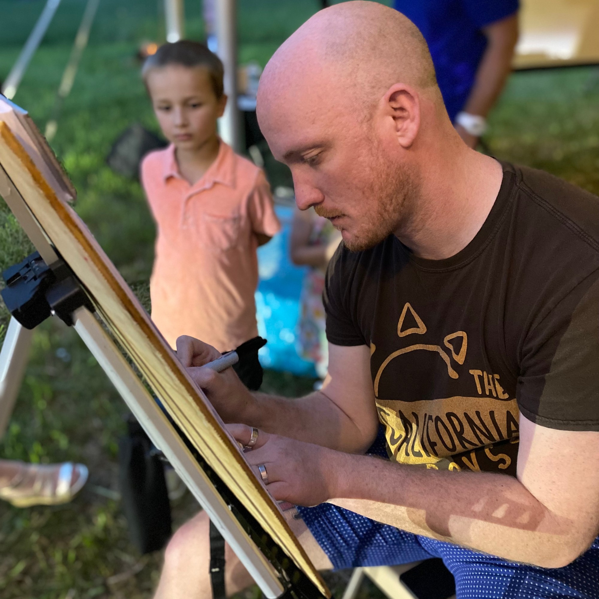 A caricature artist drawing at an easel while guests watch