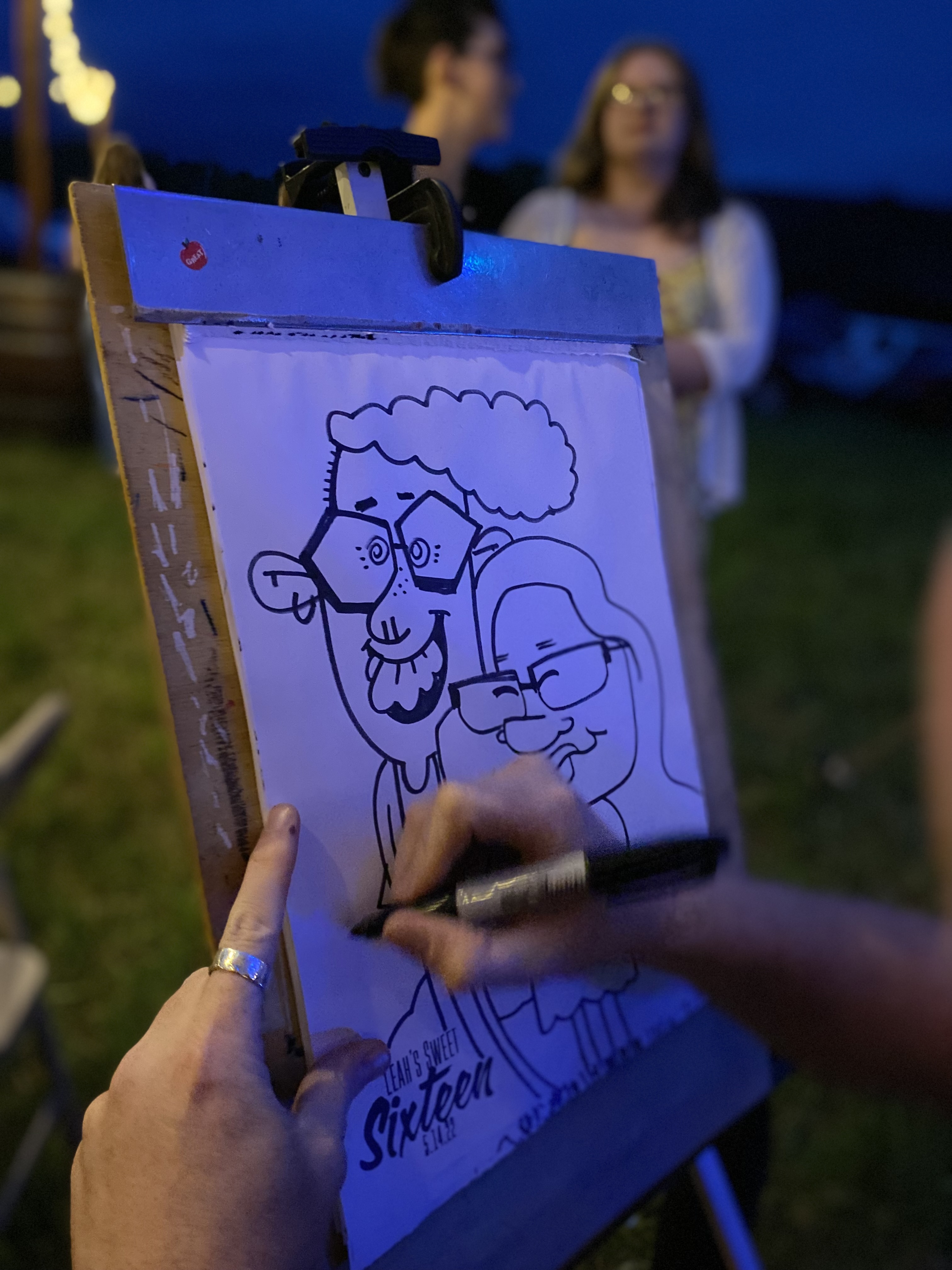 A close up shot of a caricature artist drawing black and white caricature