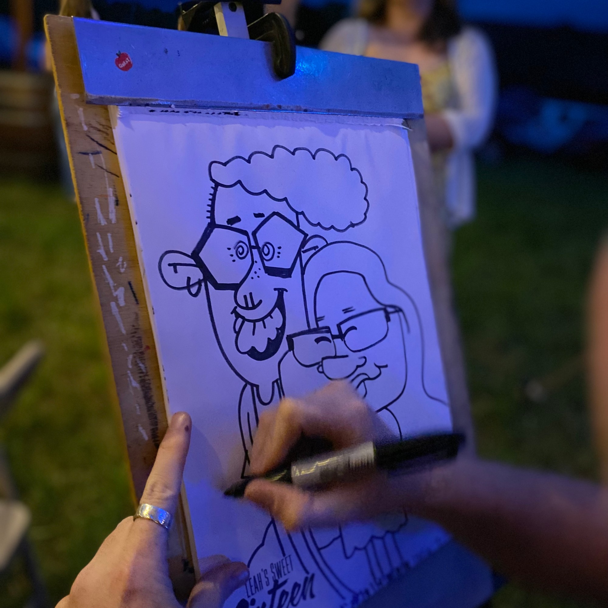 A close up shot of a caricature artist drawing black and white caricature