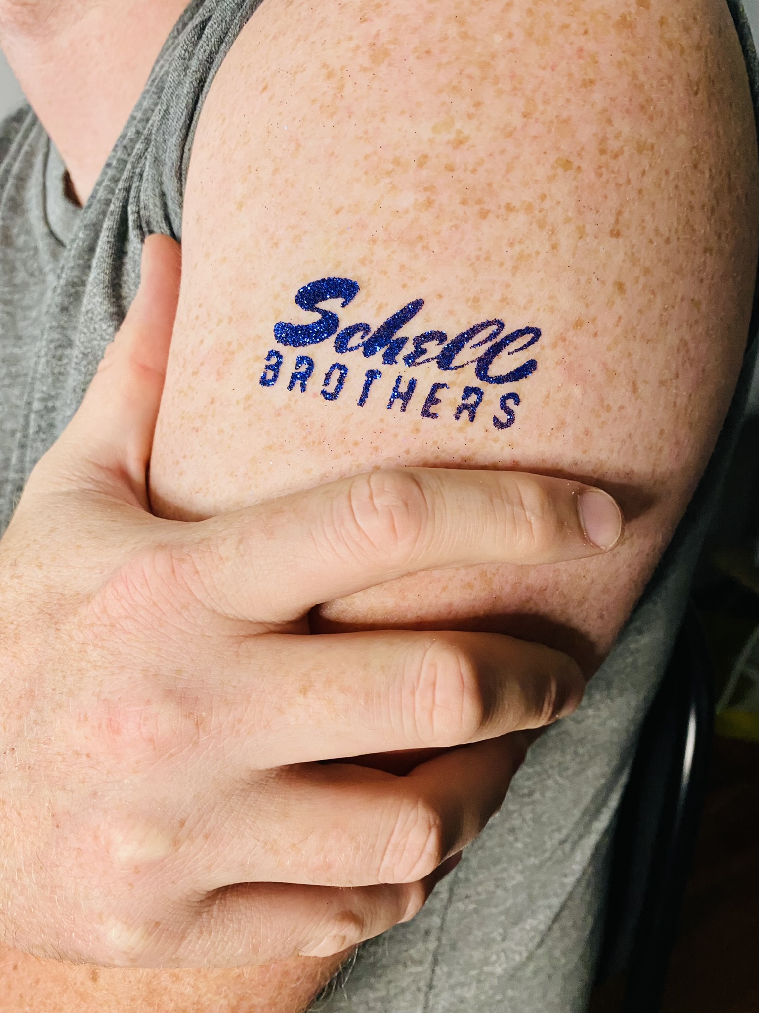 A custom sparkly navy blue Schell Brothers glitter tattoo