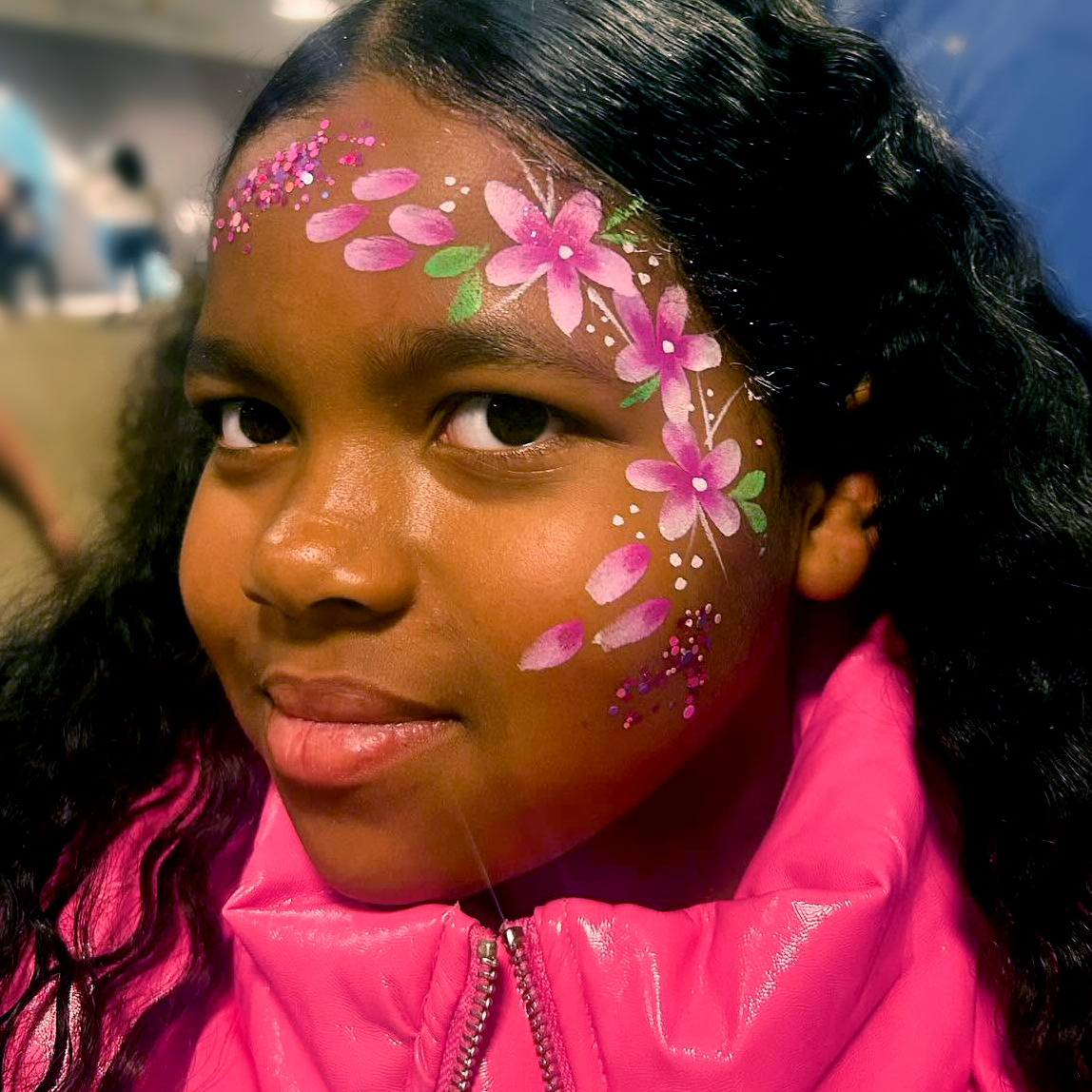 A face paint of cascading pink glittery flowers.